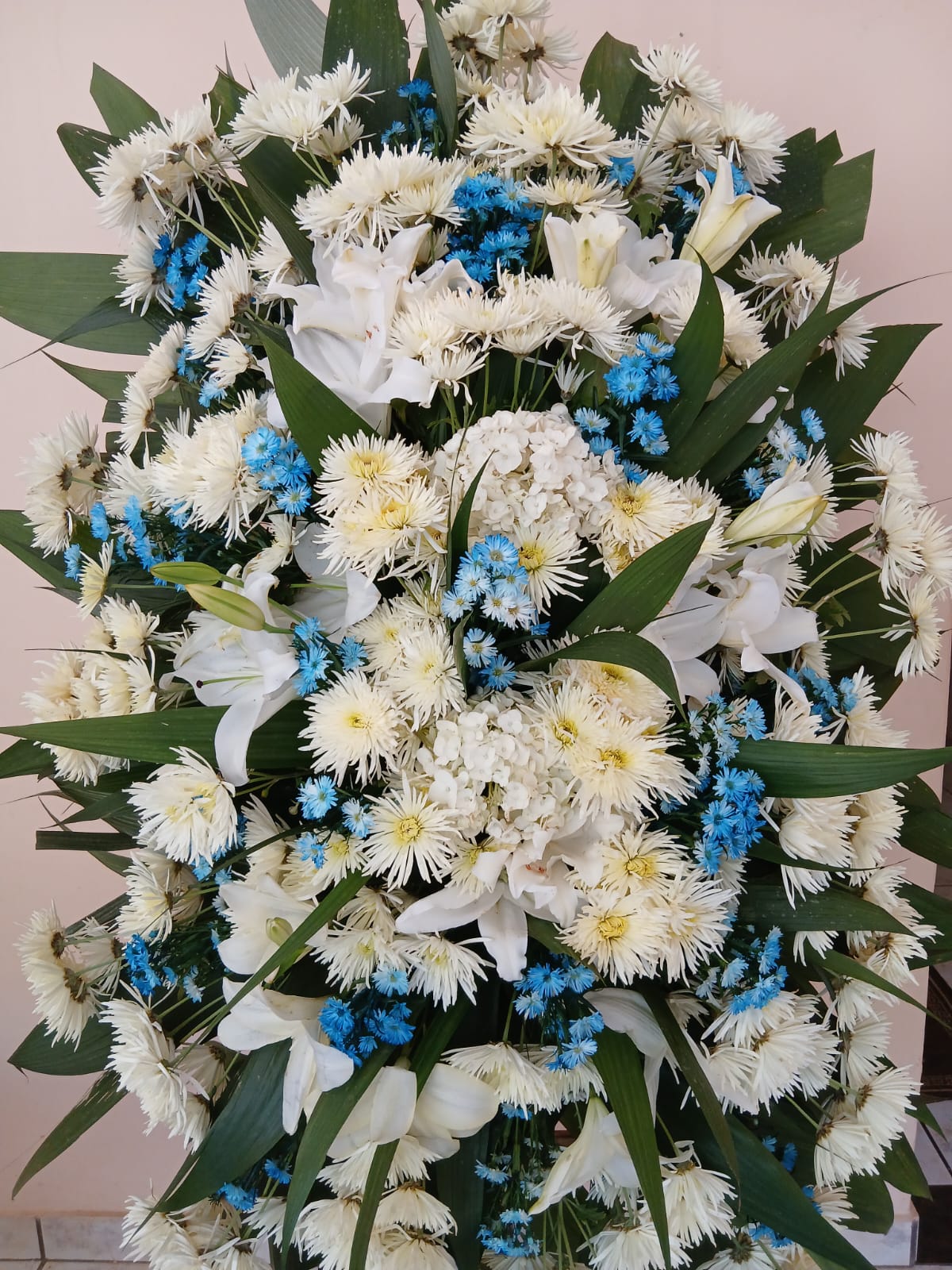 Coroas de Flores Brancas, azuis e folhagens